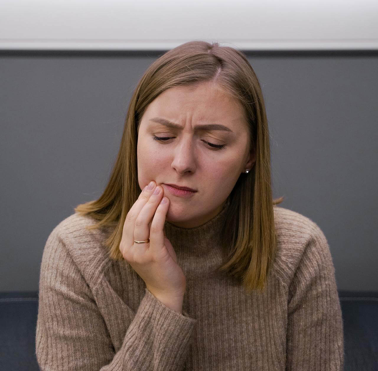 Patient holding jaw with toothache pain